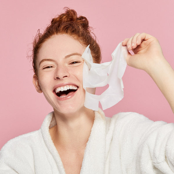 women peeling off her spotlight mask from her face